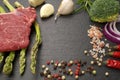 Meat food : raw beef fillet on black stone board with asparagus with dry spices ready to cooking