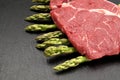 Meat food : raw beef fillet on black stone board with asparagus
