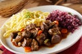 Meat goulash served for dinner with pasta and sauerkraut