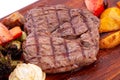 Meat grilled ribai with vegetables. Ribai steak on wooden board. Close up