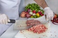 Chef is chopping the raw beef on cutting board with knife to cook in the kitchen, minced beef. Kebab restaurant, kebab preparation