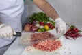 Chef is chopping the raw beef on cutting board with knife to cook in the kitchen, minced beef. Kebab restaurant, kebab preparation