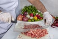 Chef is chopping the raw beef on cutting board with knife to cook in the kitchen, minced beef. Kebab restaurant, kebab preparation