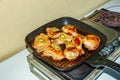 Meat with kiwi fruit. Fried chicken pieces with kiwi slices on a grill pan Royalty Free Stock Photo