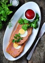 Meat loaf with boiled egg, tomato sauce, coriander and parsley on a wooden table. rustic style. Royalty Free Stock Photo