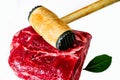 Meat mallet on raw beef meat with leaf on white background Royalty Free Stock Photo