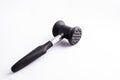 Meat mallet or tenderizer; black plastic and metal; isolated on Royalty Free Stock Photo