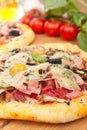 Meat and mushroom pizzas and ingredients on a wooden table
