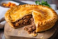 meat pie with flaky pastry and oozing chunks of tender beef