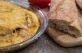 Meat pie with mushrooms and vegetables and cheese and long loaf on cut board on the table Royalty Free Stock Photo