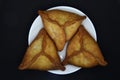 Meat pies on a white plate. Belyashi. Delicious meat pies on a black background Royalty Free Stock Photo