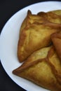 Meat pies on a white plate. Belyashi. Delicious meat pies on a black background Royalty Free Stock Photo