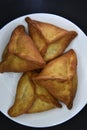 Meat pies on a white plate. Belyashi. Delicious meat pies on a black background Royalty Free Stock Photo