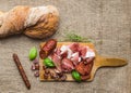 Meat plate on rustic wood board over a rough sackcloth background Royalty Free Stock Photo