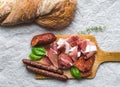 Meat plate on rustic wood board over a rough sackcloth background Royalty Free Stock Photo