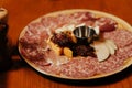 The meat plate on the served table of the restaurant is decorated with microgreens on a brown background. Sausage, cheese, ham Royalty Free Stock Photo