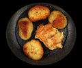 Meat and potatoes burned while frying in a pan isolated