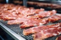 Meat processing plant. Slices of fresh bacon and mint slices on a conveyor belt in the workshop. Arrival of jamon or cold cuts.