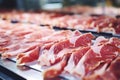 Meat processing plant. Slices of fresh bacon and mint slices on a conveyor belt in the workshop. Arrival of jamon or cold cuts.