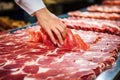 Meat processing plant. A worker sorts cold cuts on a conveyor belt. Arrival of jamon or cold cuts. Production of pork or beef in a Royalty Free Stock Photo