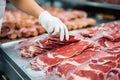 Meat processing plant. A worker sorts cold cuts on a conveyor belt. Arrival of jamon or cold cuts. Production of pork or beef in a Royalty Free Stock Photo