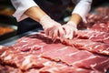 Meat processing plant. A worker sorts cold cuts on a conveyor belt. Arrival of jamon or cold cuts. Production of pork or beef in a