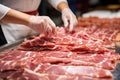 Meat processing plant. A worker sorts cold cuts on a conveyor belt. Arrival of jamon or cold cuts. Production of pork or beef in a