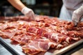 Meat processing plant. A worker sorts cold cuts on a conveyor belt. Arrival of jamon or cold cuts. Production of pork or beef in a