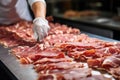 Meat processing plant. A worker sorts cold cuts on a conveyor belt. Arrival of jamon or cold cuts. Production of pork or beef in a