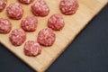 Meat Raw Balls from Raw Beef force-meat on a Chopping board. close Up. Food Preparing. Cooking. Dark Background. Royalty Free Stock Photo