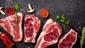 Meat raw steaks lie on a black background with vegetables, tomatoes, marasmade, mushrooms. background image Royalty Free Stock Photo