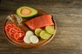 Meat red salmon fish, tomatoes, spices, onion, lemon and olive oil on kitchen table background. Copy space