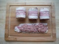 meat rolls in bacon on a wooden table, the cooking process Royalty Free Stock Photo