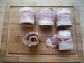 meat rolls in bacon on a wooden table, the cooking process Royalty Free Stock Photo