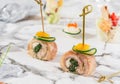 Meat rolls with ham, cream cheese and greens on marble banquet table. Catering food, canape and snacks, close up. Royalty Free Stock Photo
