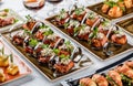 Meat rolls with prosciutto, cream cheese and greens in plate on banquet table. Catering food, canape and snacks Royalty Free Stock Photo