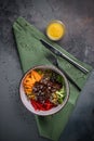 Meat salad with Beef Tenderloin, vegetables, orange, sesame seeds and herbs on a plate top view. Spoon and fork on a green