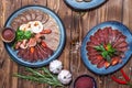 Meat and sausage cuts, garlic, chili peppers, tomatoes and other spices on a wooden brown background