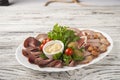 Meat and sausage sliced on a plate with nuts, garlic sauce. Pastrami, baked ham, chorizo, bacon, olives, cherry tomatoes on a plat Royalty Free Stock Photo