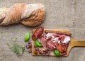 Meat selection / wine set on a rustic wood board over a rough sa Royalty Free Stock Photo