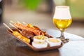 Meat on skewers grilled on fire and a glass of beer Royalty Free Stock Photo