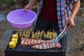 Meat and skewers ingredients for barbecue party are placed on grill to cook barbecue and make it ready for family to join barbecue
