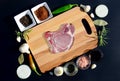 Meat steak on a cutting board and pepper, bay leaf, rosemary, onions, salt, olive oil, soy sauce Royalty Free Stock Photo