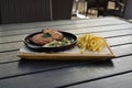 Meat steak on frying pan with mushroom and fried potatoes