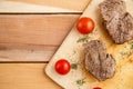 Meat steaks on a wooden tray on a wooden background. Top view Royalty Free Stock Photo