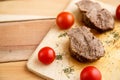 Meat steaks on a wooden tray on a wooden background. Top view Royalty Free Stock Photo