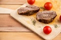 Meat steaks on a wooden tray on a wooden background. Top view Royalty Free Stock Photo