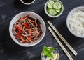 Meat stir fry with sweet red pepper, steamed rice and fresh cucumber and sesame salad Royalty Free Stock Photo