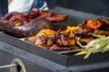 Meat and vegetables are grilled on the kitchen`s large trailer grill, chicken wings and meat ribs Royalty Free Stock Photo