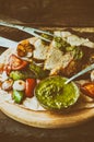 Meat with vegetables, grilled and served Italian Salsa Verde sauce. Wooden rustic table. Close-up